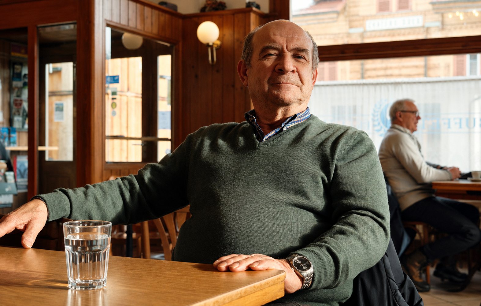 Clive sitting at a table with a glass of water